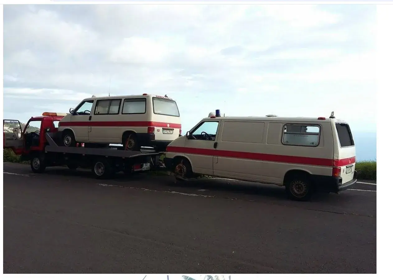 Reboque a transportar uma carrinha, com outra carrinha atrás